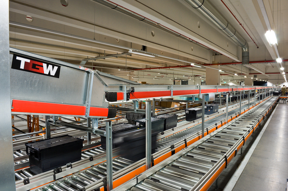 Accumulation roller conveyors moving totes through a distribution hall